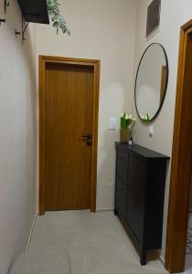 a room with a wooden door and a dresser with a mirror at Apartman Aleksandra 2 in Bečej