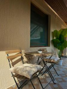 a table and two chairs sitting next to a wall at Apartman Aleksandra 2 in Bečej