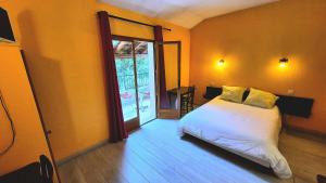 a bedroom with a bed and a sliding glass door at Le Terminus in Ax-les-Thermes