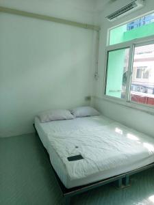 a bed in a room with a window at Urban Nest Hostel in Bangkok
