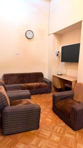 a living room with two couches and a flat screen tv at lala salama in Zanzibar City