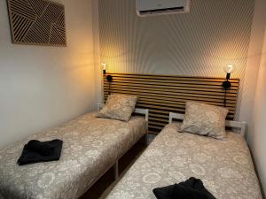 two beds in a room with black towels on them at Résidence le 1564 Vert in Roussillon en Isere