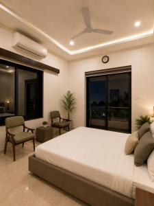 a bedroom with a bed and a clock on the wall at Kanchan Jayanti Villa in Khandāla +26 photos