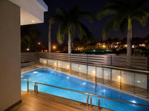 a swimming pool at night with palm trees at Kanchan Jayanti Villa in Khandāla