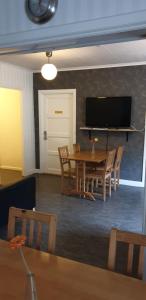 a living room with a table and chairs and a television at Lönneberga Vandrarhem & Hostel in Lönneberga