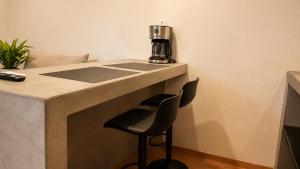 a bar with a black stool under a counter with a coffee maker at Oros Jalatlaco in Oaxaca City