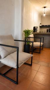 a living room with two chairs and a kitchen at Oros Jalatlaco in Oaxaca City +1 photo