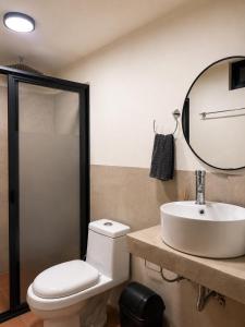 a bathroom with a toilet and a sink and a mirror at Oros Jalatlaco in Oaxaca City