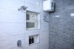 a bathroom with a shower with a window at Kings Residency in Chennai