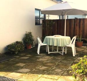 a table and chairs with an umbrella on a patio at Kunsvilla in Durbanville