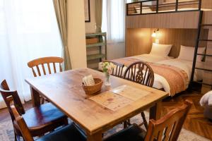 a room with a table and a bunk bed at 7 Rooms Hotel & Cafe - ディズニーと空港までバス1本 - 全室キッチン付き in Tokyo