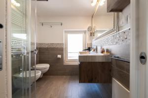 a bathroom with a toilet and a sink and a shower at Hotel Lago Di Garda in Malcesine +133 photos