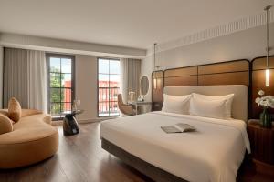 a hotel room with a large bed and a chair at Solaria d'Oriente Hotel in Hanoi