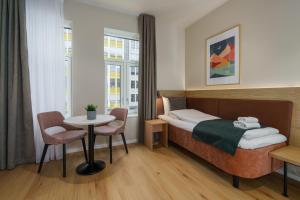 a hotel room with a bed and a table and chairs at MAYA Apartments - Vika in Oslo