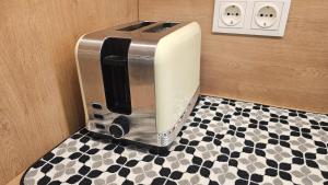 a toaster on a counter with a checkered floor at Lake Apartment in Šiauliai