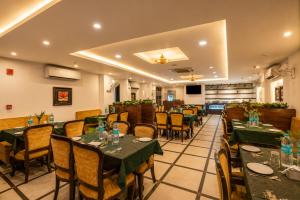 a restaurant with tables and chairs in a room at Airport La Sapphire Hotel & Restaurant in New Delhi
