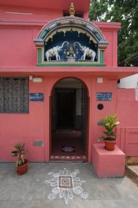 a red building with a clock on top of it at KHS Ranganath-U in Tiruchirappalli