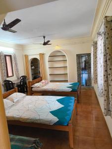 a room with three beds in it at KHS Ranganath-U in Tiruchirappalli