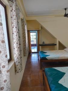 a small room with two beds and a window at KHS Ranganath-U in Tiruchirappalli