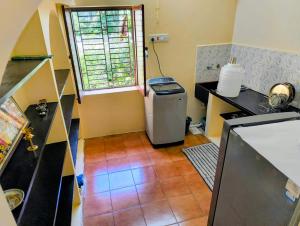 a small kitchen with a refrigerator and a window at KHS Ranganath-U in Tiruchirappalli