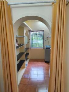 a hallway with an archway in a kitchen with a window at KHS Ranganath-U in Tiruchirappalli +2 photos