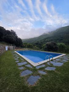 a swimming pool in a field with mountains in the background at Nova Forest Montseny in Montseny