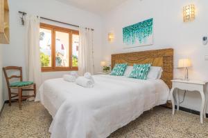 a bedroom with a large white bed and a desk at Sol I Vent in Cala Santanyi