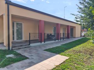 a building with red pillars on the side of it at PiaveHome in San Donà di Piave