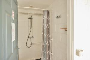 a shower with a shower curtain in a bathroom at College Farm by Feather Down in Beccles
