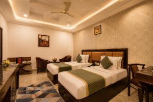 a hotel room with two beds and a desk at Airport La Sapphire Hotel & Restaurant in New Delhi +54 photos