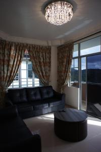 a living room with a couch and a chandelier at Cameron View Apartment @ Crown Imperial Court Brinchang in Cameron Highlands