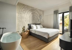 a bedroom with a large bed and a bath tub at AIONION RESIDENCES by K&K in Athens