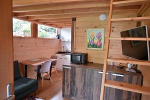 a room with a kitchen and a desk with a television at Grajski oddih in Cerklje na Gorenjskem