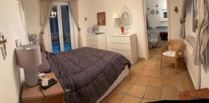 a bedroom with a bed and a table and a bathroom at VILLA CLARA ISCHIA piscina riscaldata e idromassaggio in Lacco Ameno
