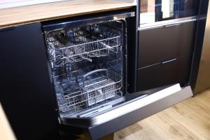 an open dishwasher with a dish rack in it at Casa Rural La Canaleja in Berrocalejo