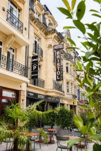 ein Gebäude mit Tischen und Stühlen davor in der Unterkunft Hotel Bristol in Luxemburg (Stadt)