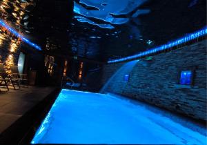an indoor swimming pool with blue lights in a building at Liptovský mlyn in Bešeňová