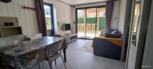 a living room with a dining room table and a television at PRL El Pastural in Err