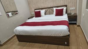 a bedroom with a large bed with red pillows at YU Turn Celebrations in Greater Noida