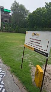 a sign sitting in the grass next to a field at YU Turn Celebrations in Greater Noida