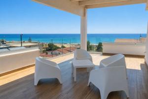 a room with white chairs and a view of the ocean at Almarea Cirò Marina in Cirò Marina