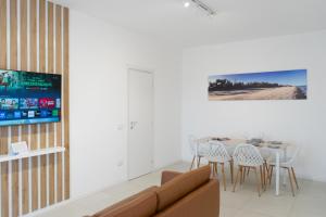 a living room with a couch and a table with chairs at Almarea Cirò Marina in Cirò Marina