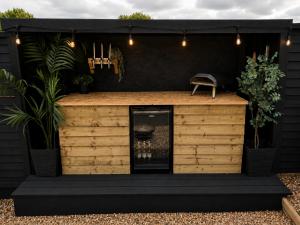 a barbershop with a black wall and a black roof at The Nest @The Outside Inn in Mountfield