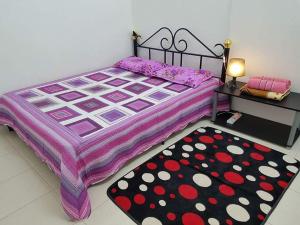 a bedroom with a large bed and a rug at Lynn Homestay Jitra in Jitra