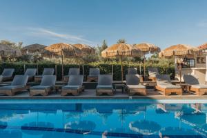 a pool at a resort with chairs and umbrellas at Agrilia Hotel Adults Only in Laganas