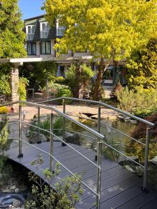 a bridge over a pond with a house in the background at Papuga Park Hotel Wellness Marrakesz & SPA in Bielsko-Biała +74 photos