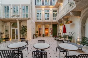 a patio with tables and chairs in a building at NOLIA Boutique Hotel in Porto