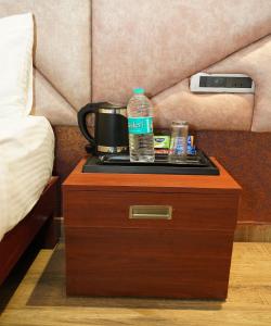 a table with a coffee pot and a bottle of water on it at Hotel G Grand Inn in Thanjāvūr