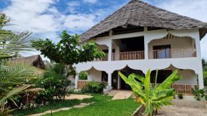 a villa with a balcony in a resort at Bantu Home in Paje