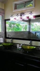 baño con 2 lavabos verdes y ventana en Serenity Beach Cottages, en Utila